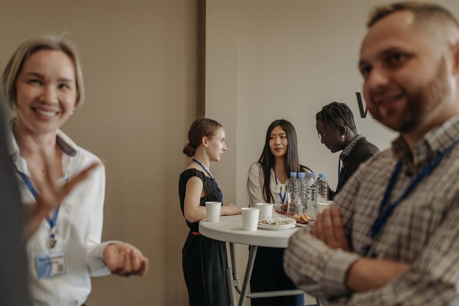Smiling attendees with name badges talking at an event