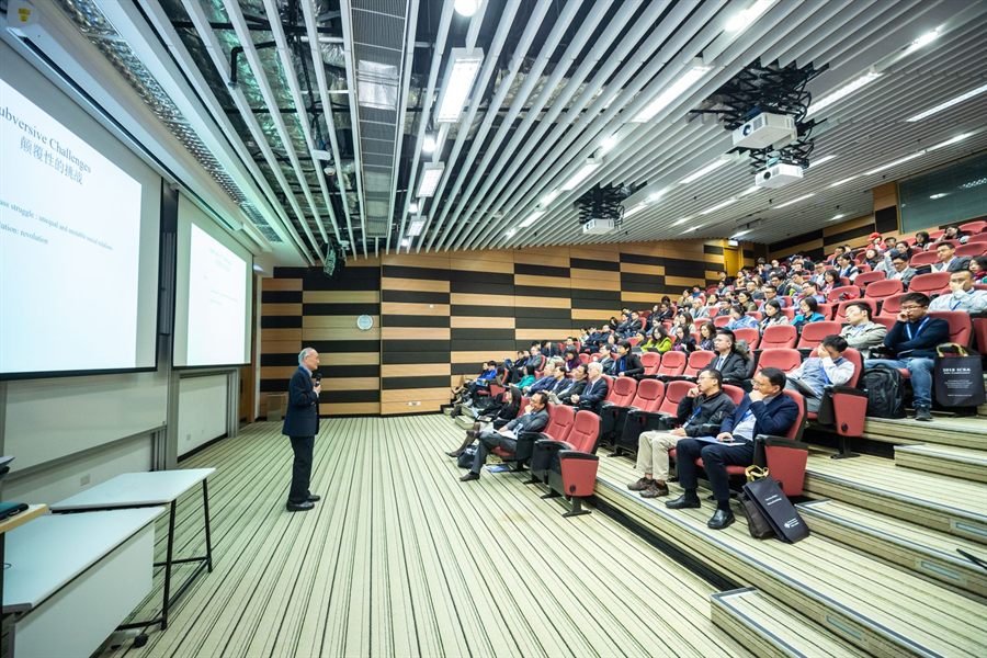 Speaker presenting to an audience in a tiered lecture hall