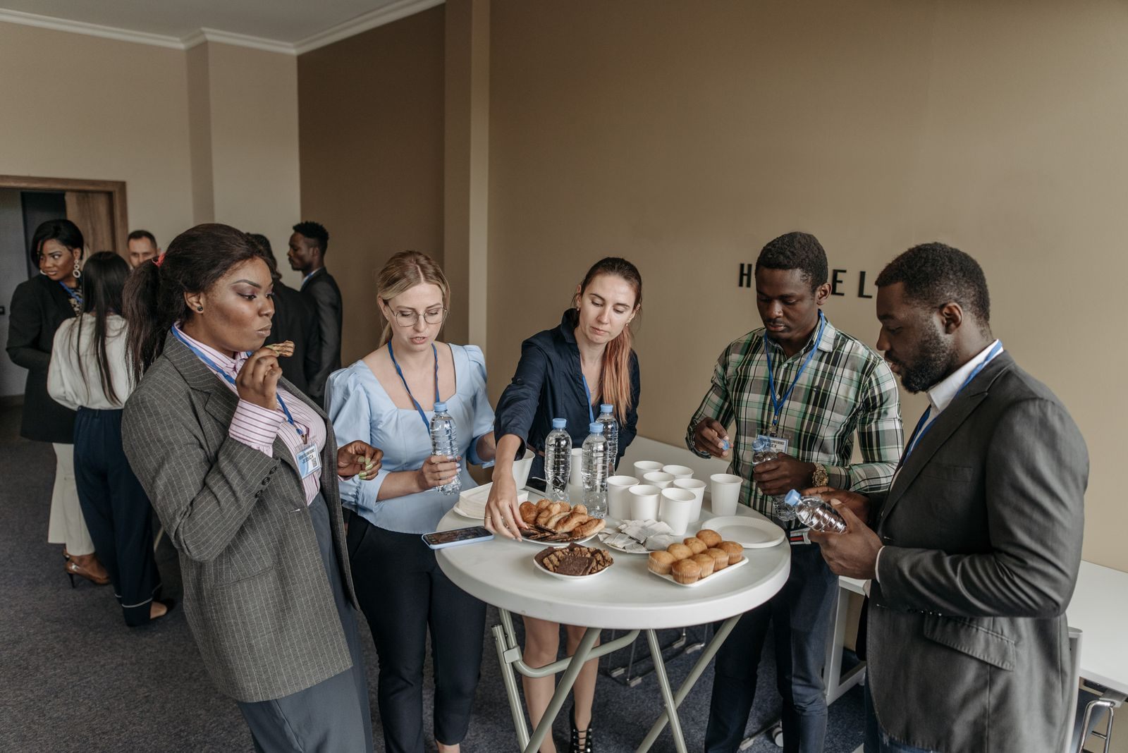Attendees chatting over coffee at standing tables during an event break